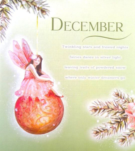 A decorative December-themed illustration with a fairy seated on a large pink and orange ornament, surrounded by pine branches and a soft pale green background. The word 'DECEMBER' appears at the top with a short poem below.