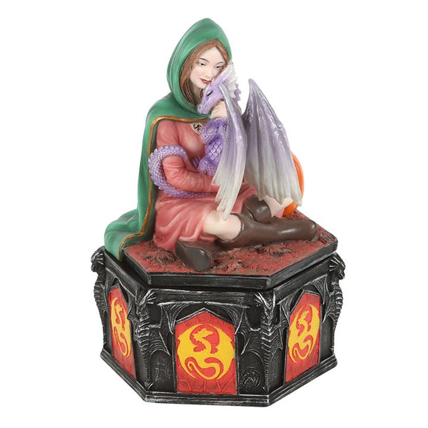 Figurine of a hooded figure with a dragon on a decorative base with dragon symbols.