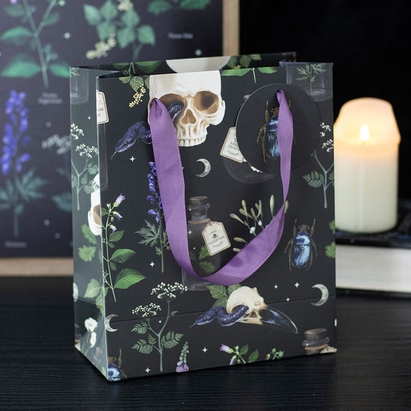 Gift bag with skull and plant design on a dark background
