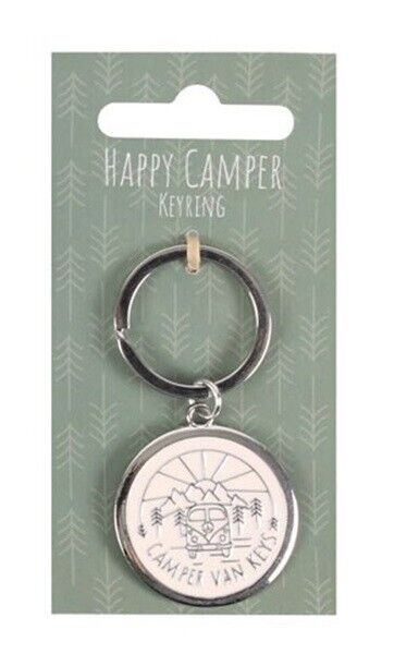 A silver metal keyring with a round charm featuring a black line art illustration of a vintage camper van surrounded by trees, hanging from a green card labeled 'HAPPY CAMPER KEYRING'.
