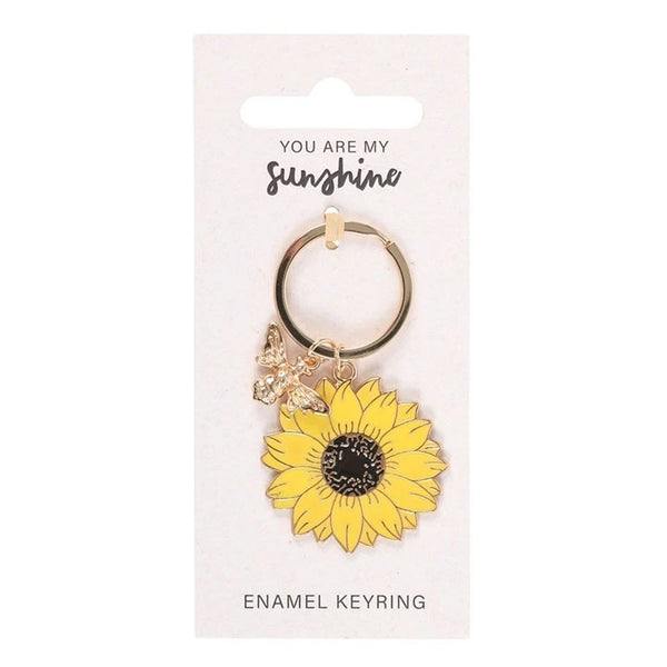 Yellow Sunflower & Bee Keyring

* Metal
* Sunflower Size: 4cm x 4cm
* Bee Gold Colour Size: 2.5cm x 2cm
* Made by Jones Home &amp; Gift Ltd


Measuring 4 cm in length and width, this unisex keychain is perfect for adding a touch of charm to any purse or bag.

This keyring is a delightful accessory for those who appreciate animal and insect-themed accessories.

Brighten up someone's day with this sweet and cheerful sunflower keyring. This timeless design comes on a 'You are my sunshine' backing card, mak